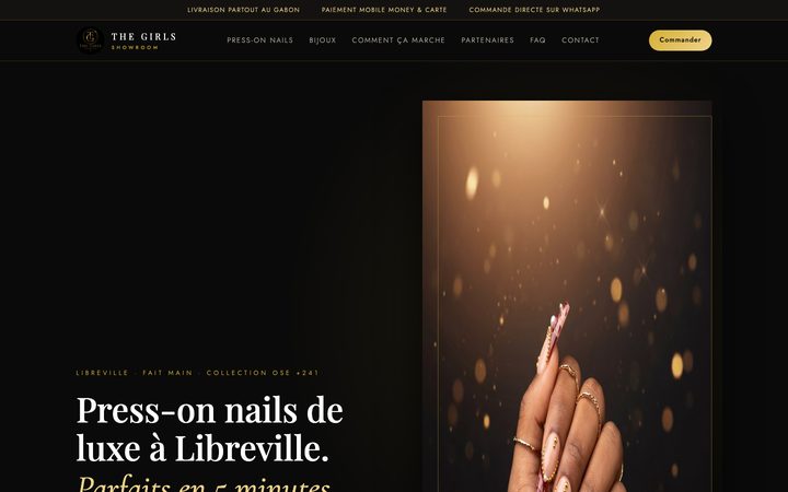 La pagina iniziale del sito The Girls Showroom: press-on nails dorate su fondo scuro e menu in francese